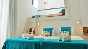 A bunk bed room with a skylight, two pillows with cartoon characters, and a ladder. - Peneco Albufeira GuestHouse - Hostel (Albufeira)