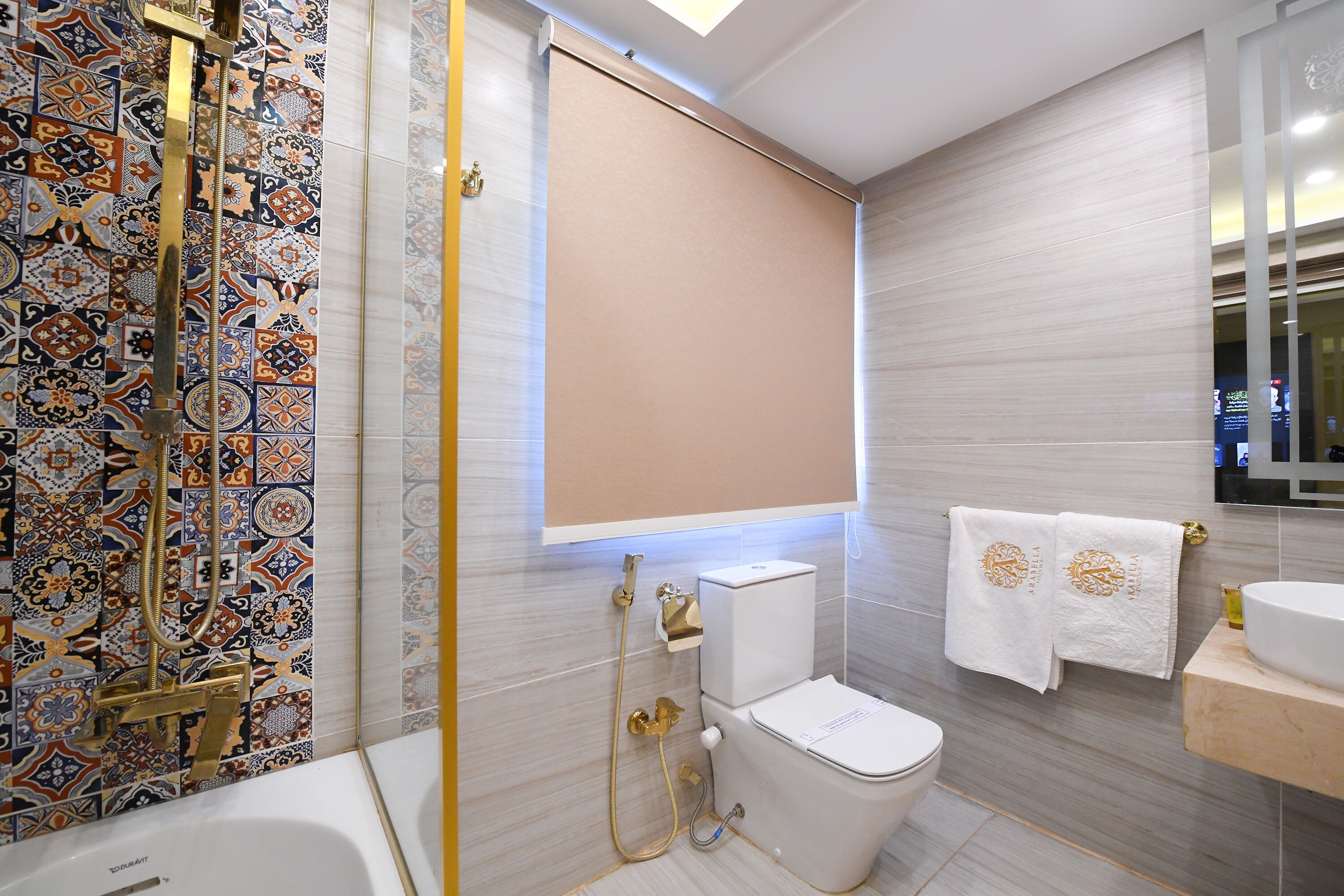A bathroom with a shower, toilet, and sink.