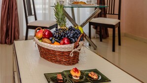 A dining table with a fruit basket, a glass table, and chairs. - Arabella Residence (New Cairo)