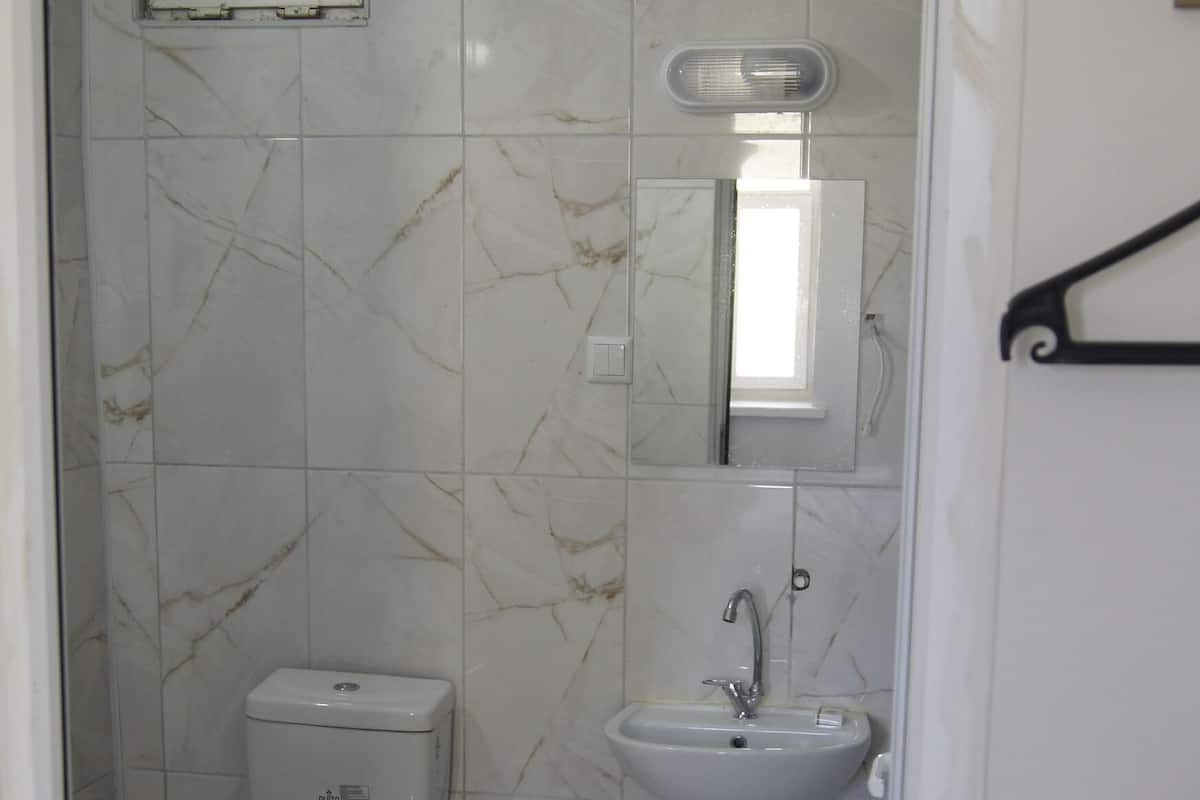 Une petite salle de bain avec des toilettes, un lavabo et un miroir.