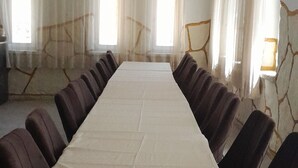 A conference room with a long table, chairs, and large windows with curtains. - Sunrise Güneş Motel (Pütürge)