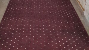 A hallway with a red patterned carpet, white walls with stone accents, and a stone staircase leading to a landing. - Sunrise Güneş Motel (Pütürge)