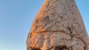 A large rock formation with a carved face, surrounded by smaller rocks and sparse vegetation. - Sunrise Güneş Motel (Pütürge)