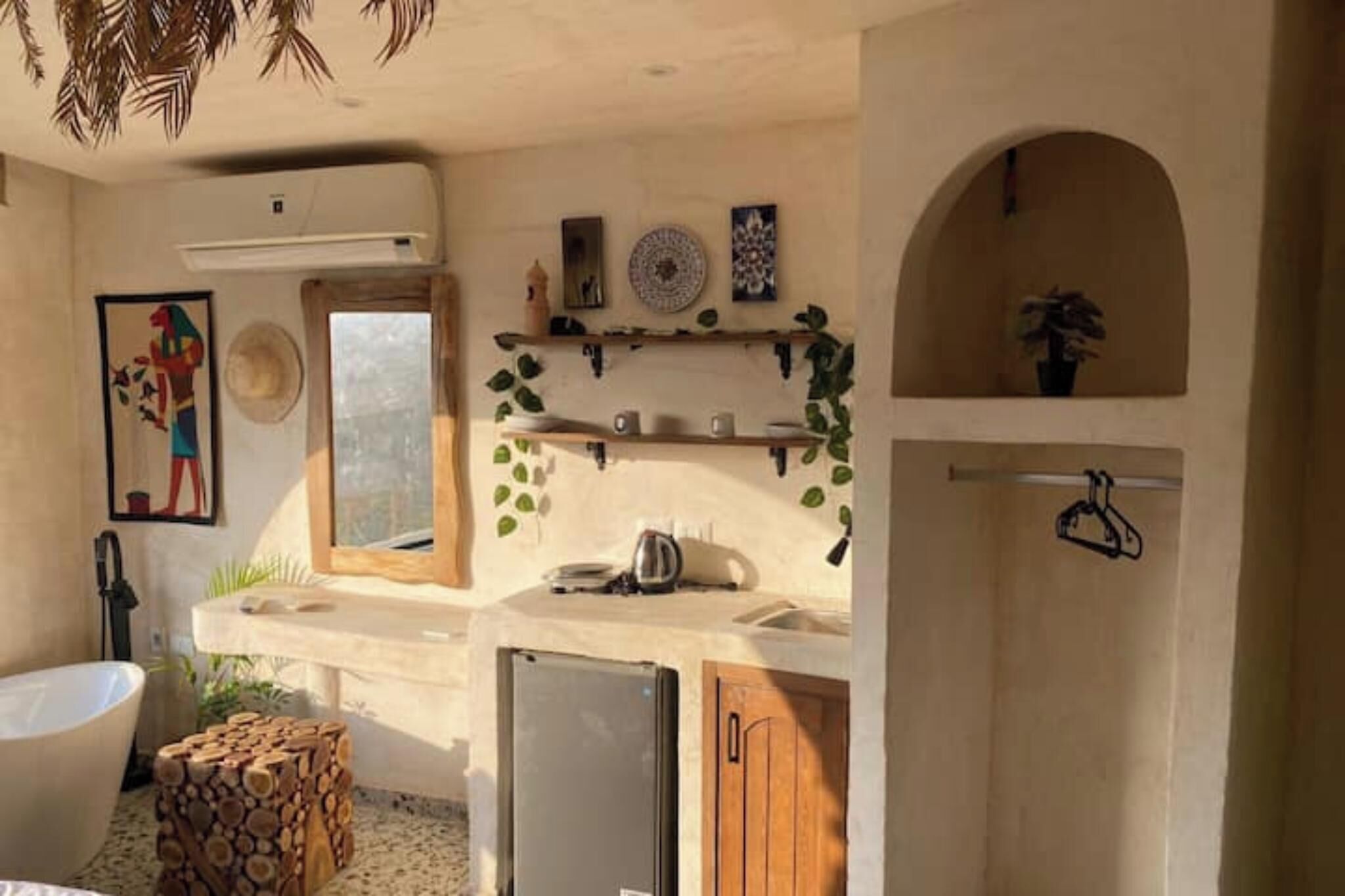 A compact kitchen with a refrigerator, sink, and wooden cabinets.