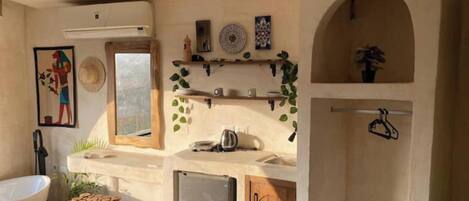 A compact kitchen with a refrigerator, sink, and wooden cabinets.