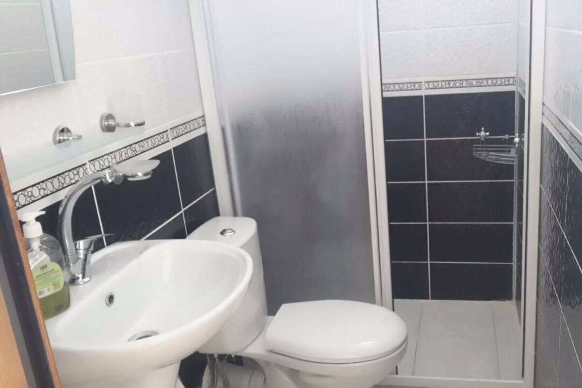 A bathroom with a white sink, toilet, and shower.