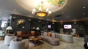 A spacious lobby with a large chandelier, comfortable seating, and a television screen. - Funda Hotel (Trabzon)