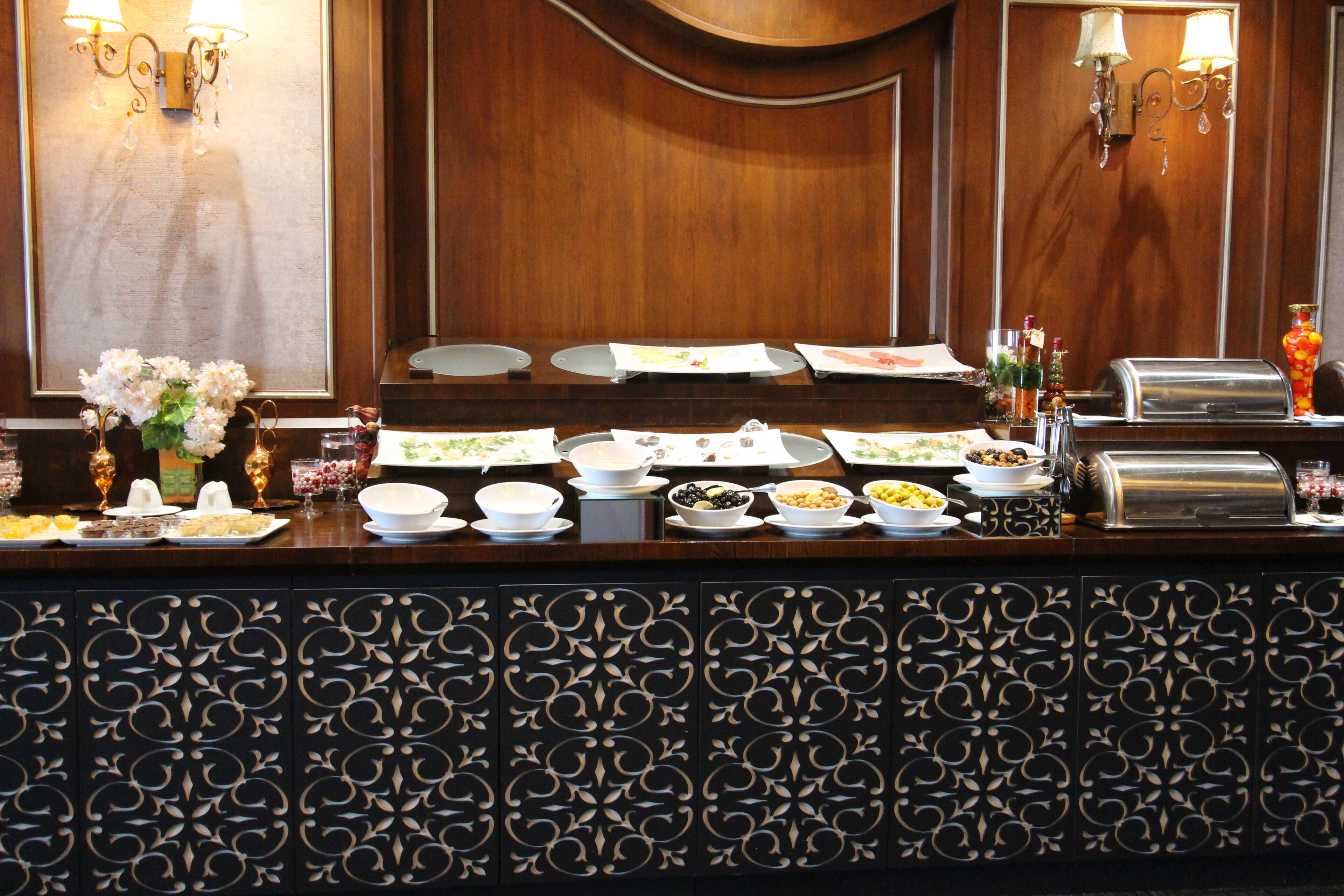 A buffet setup with various food items and a salad bar.