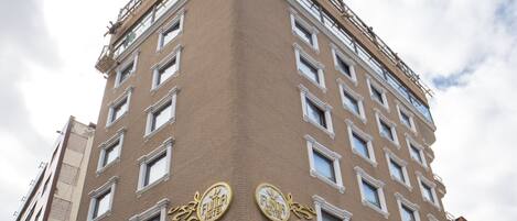 Un edificio de varios pisos con un llamativo letrero de 'Funda Hotel' en la planta baja.