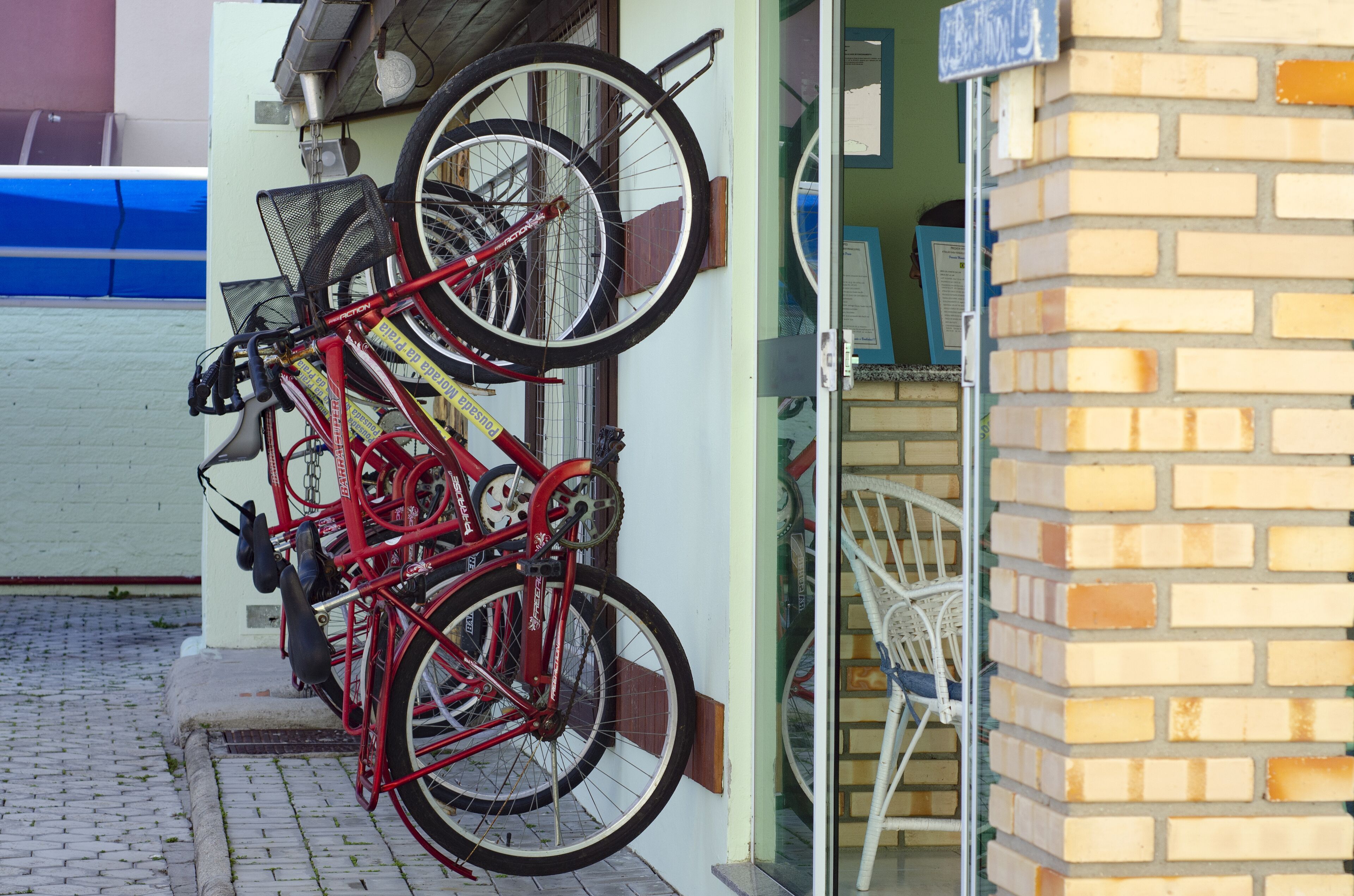 Un vélo appuyé contre un mur, avec une porte et un mur de briques en arrière-plan.