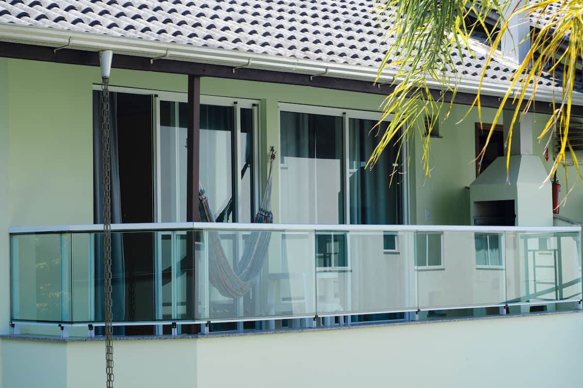Ein modernes Gebäude mit Balkon, großen Fenstern und einem Ziegeldach.
