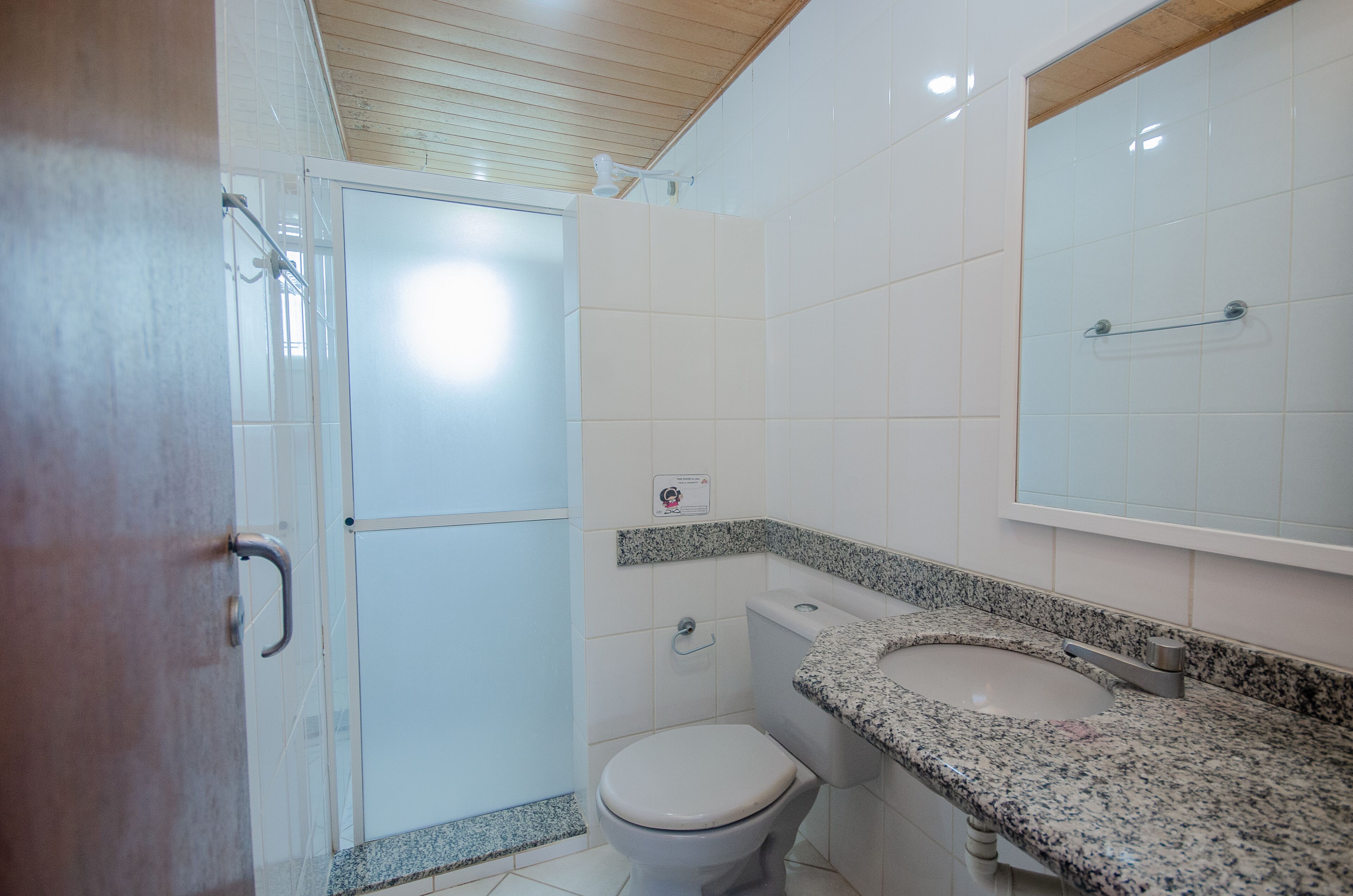 A bathroom with a shower, toilet, and two sinks.