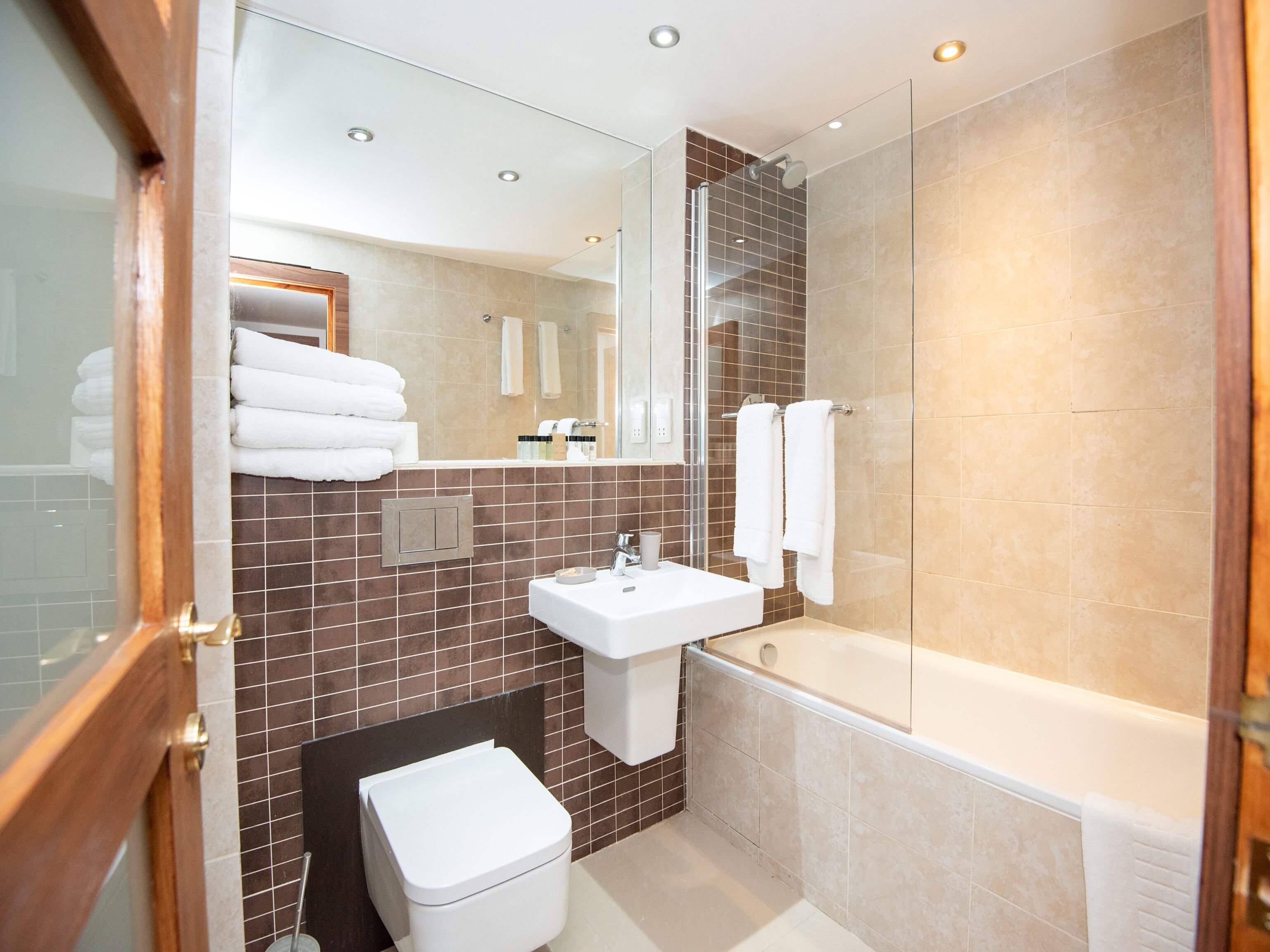 A modern bathroom with a glass shower enclosure, a white sink, and a bathtub.