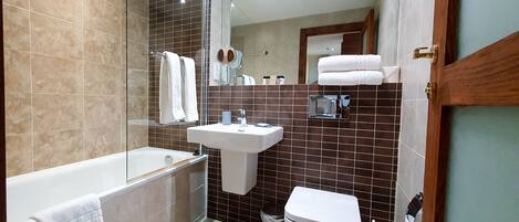 Un baño moderno con bañera, lavamanos e inodoro.