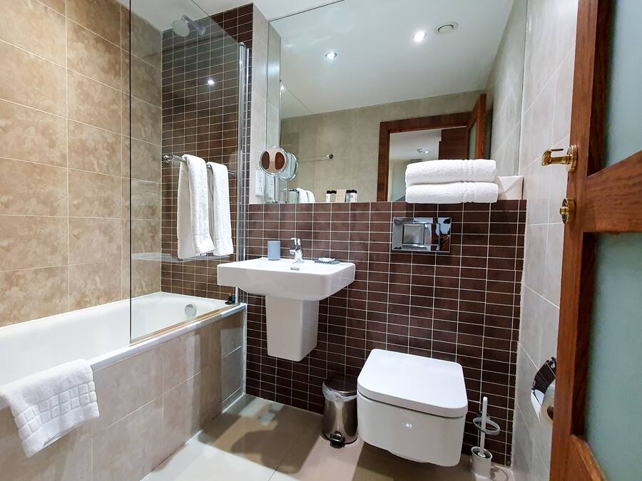 Un baño moderno con bañera, lavamanos e inodoro.