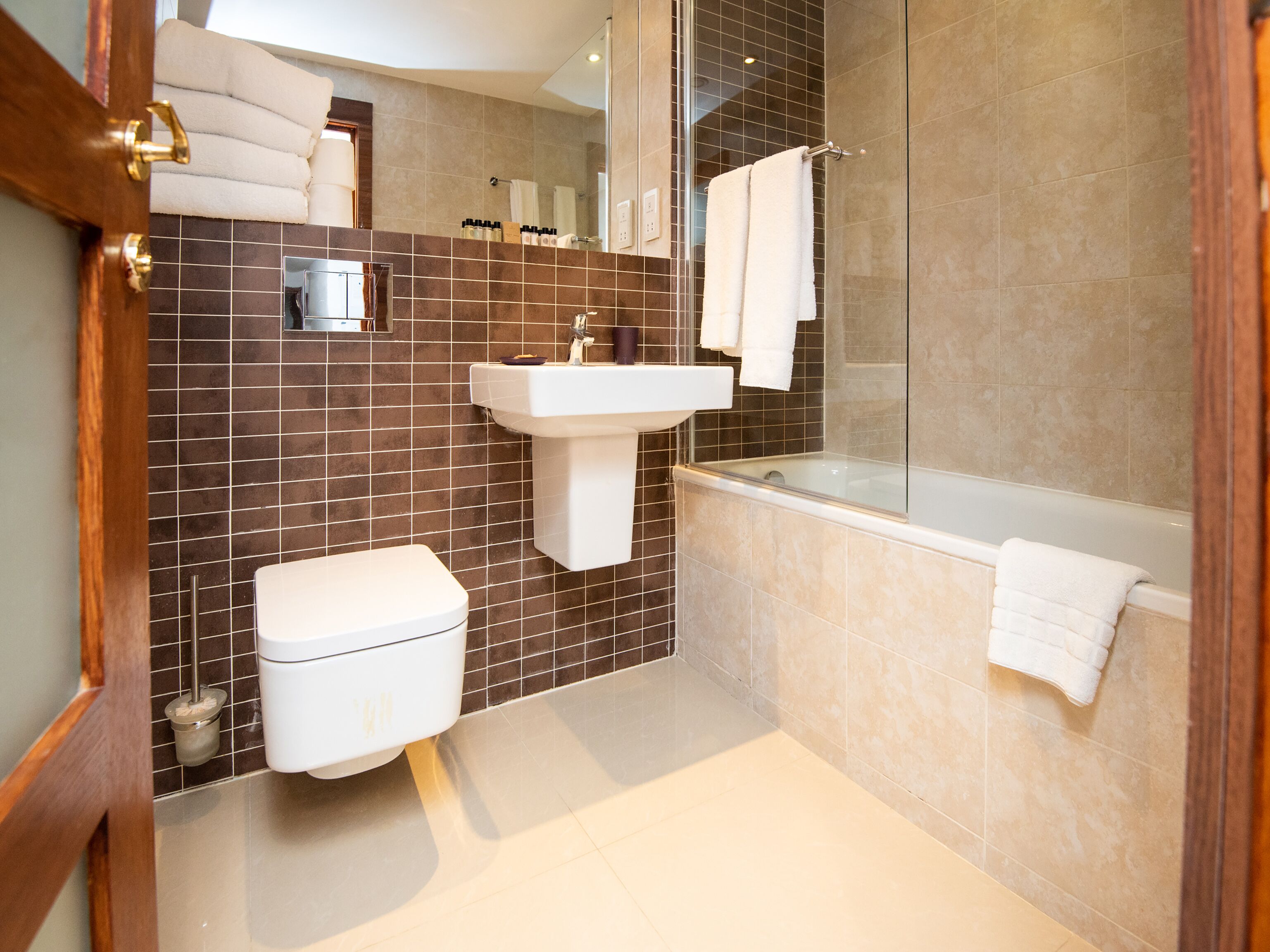 A modern bathroom with a toilet, sink, and bathtub.