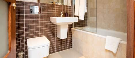 Un baño moderno con inodoro, lavamanos y bañera.