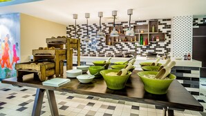 A modern kitchen with a checkered floor, wooden and green bowls, and hanging pendant lights. - Livin’ Serviced Apartments (Watford)