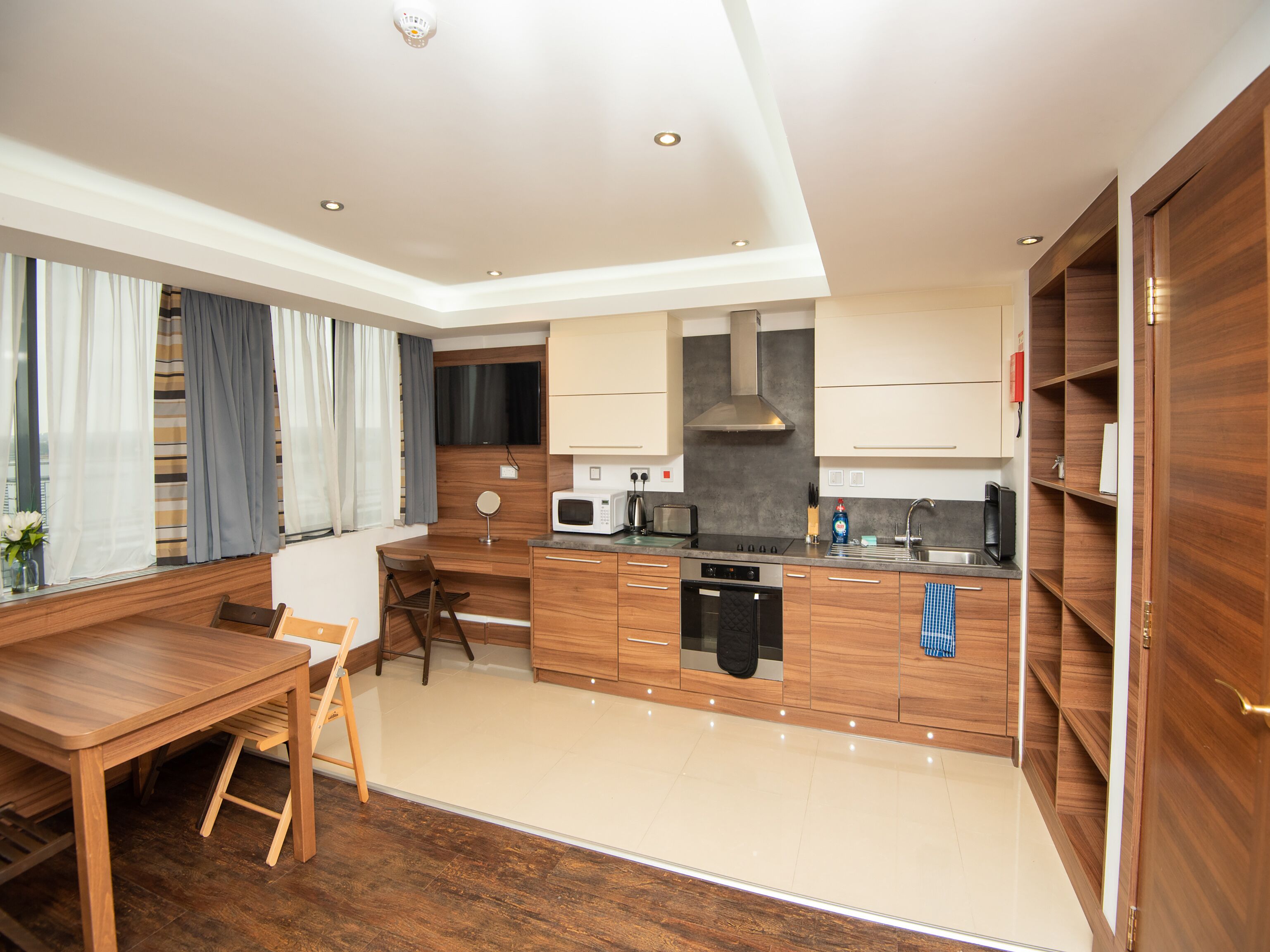 A modern kitchen with wooden cabinets, a built-in microwave, a stove, and a sink.