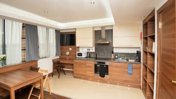 A modern kitchen with wooden cabinets, a built-in microwave, a stove, and a sink.