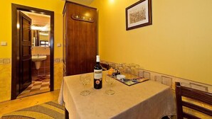 Un coin repas avec une table mise pour deux, une bouteille de vin et des verres.