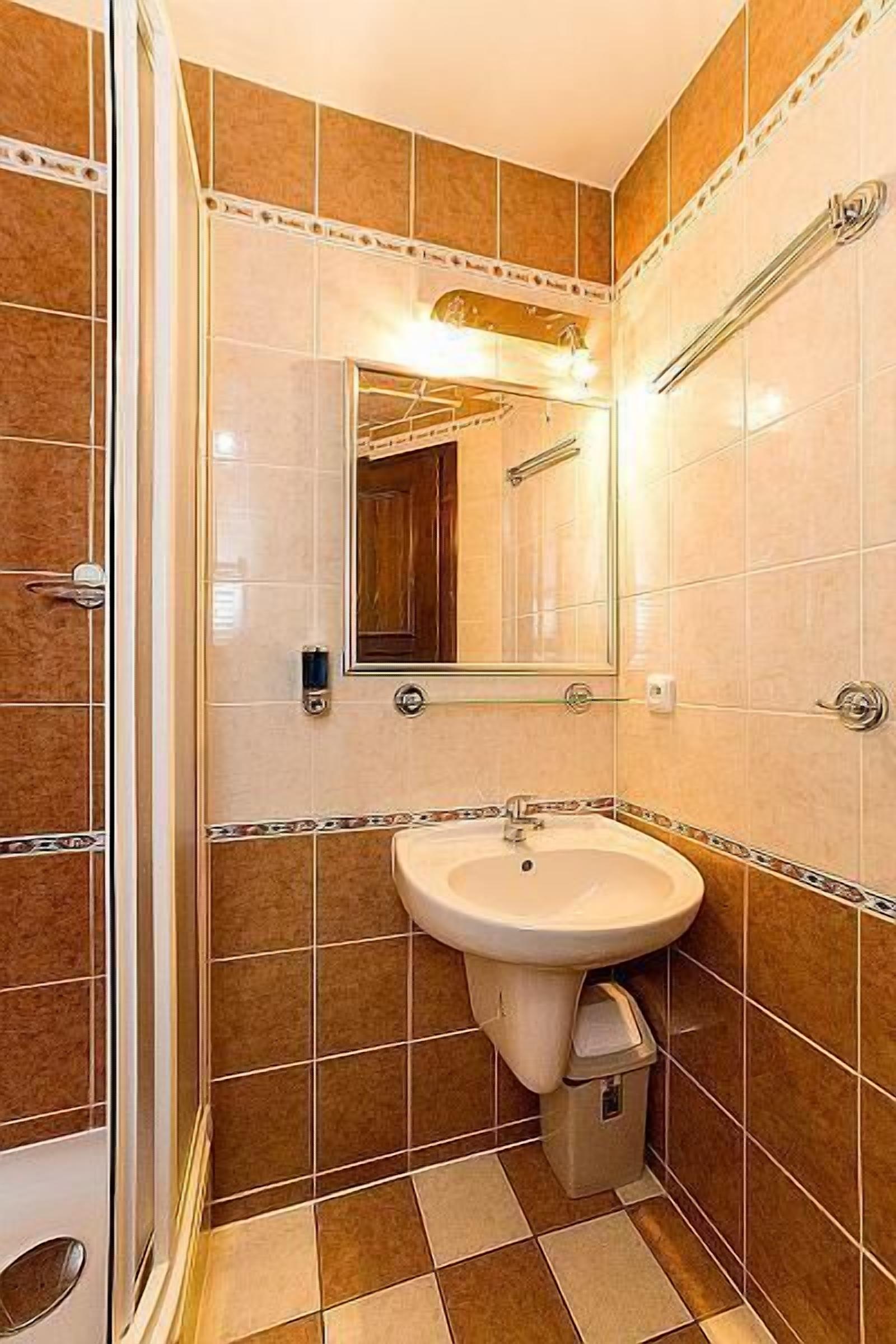 Ein Badezimmer mit Waschbecken, Spiegel und Dusche.