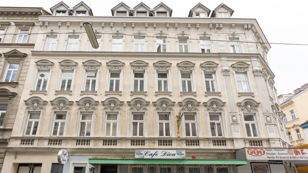 Un edificio histórico con una cafetería llamada 'Cafe Diva' en la planta baja.