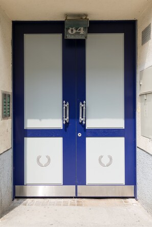Uma porta dupla azul com um sinal de número em cima.