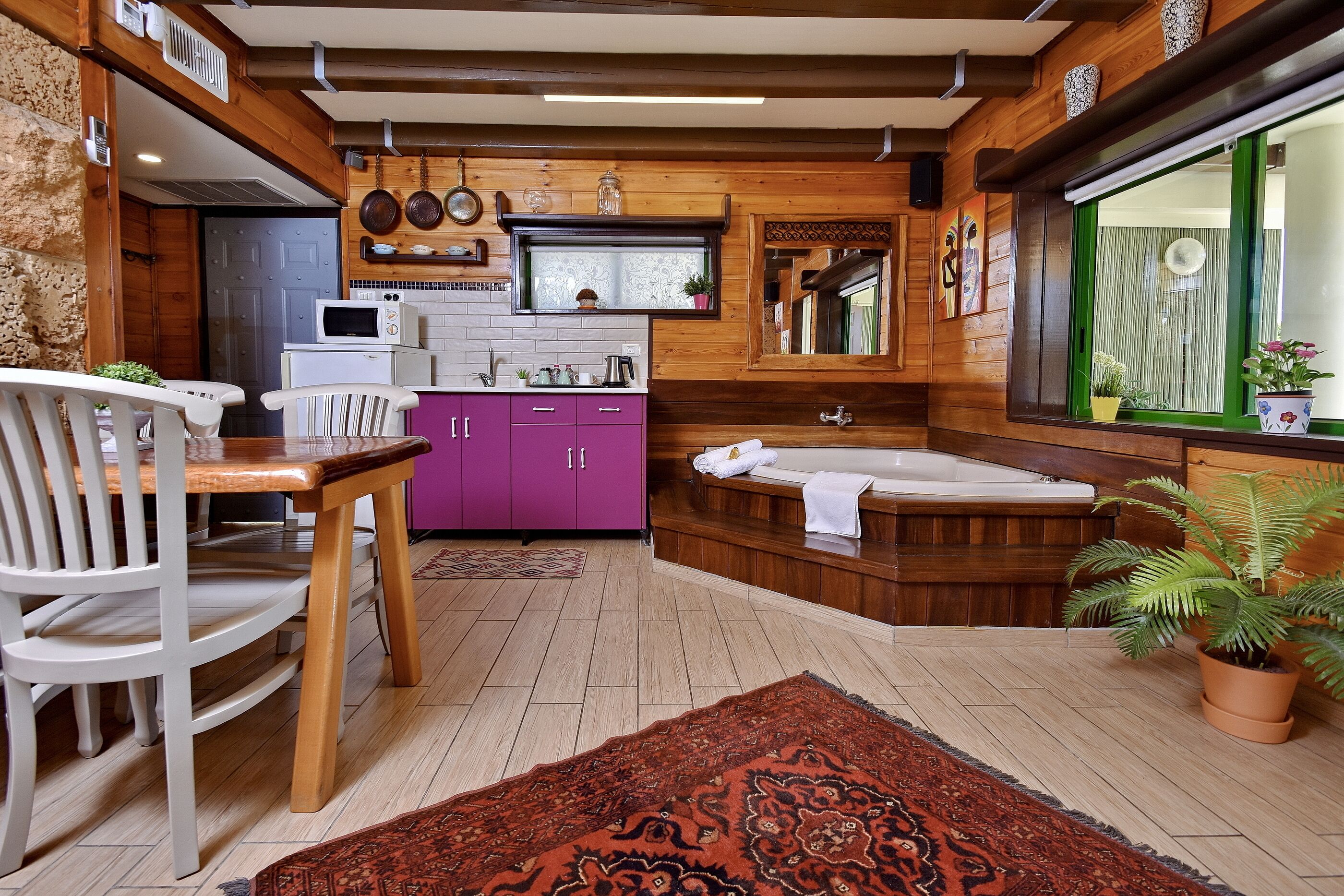 Une cuisine moderne avec des éléments en bois, un meuble violet et un four à micro-ondes encastré.