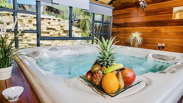 A hot tub with fruit and a stone wall view. - Out of Africa Sea of Galilee Resort (Had Nes)