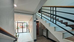 A modern interior with a staircase, a welcome mat, and a view of the outside. - Graphic House at Chiang Rai (Chiang Rai)
