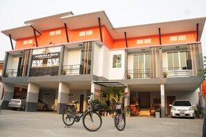 A multi-story building with a modern design, featuring balconies and large windows.