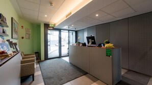 A reception area with a reception desk, seating area, and a view of the outside.