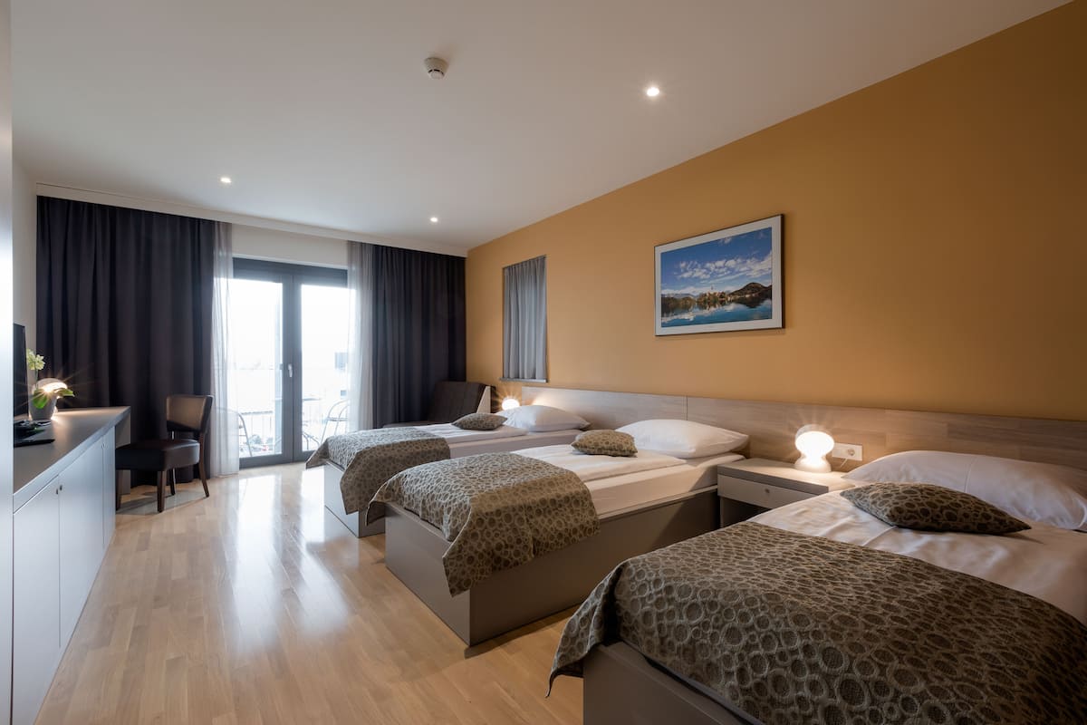 Habitació d'hotel amb dos llits, un escriptori i una cadira.