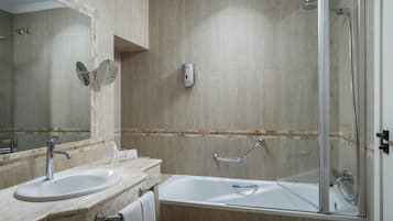 A bathroom with a sink, mirror, and shower area.