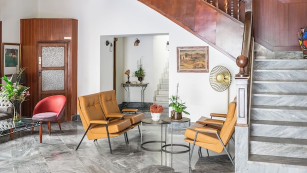 A spacious lobby with a grand staircase, comfortable seating, and a decorative stained glass window. - BYPILLOW California (Málaga)