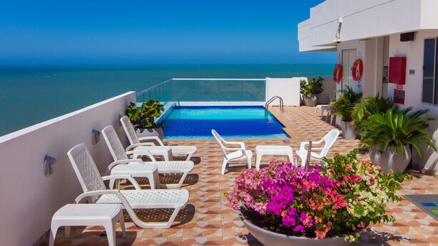 A rooftop pool area with white lounge chairs, a swimming pool, and potted plants. - Hotel Aixo Suites By Geh Suites (Cartagena)