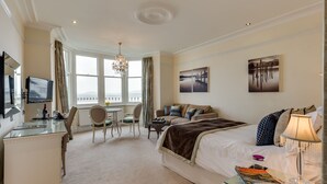 A hotel room with a bed, a desk, a chair, a table, and a TV. - Number 43 (Carnforth)