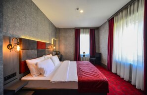 A modern hotel room with a large bed, a desk, and a view of the city. - A11 Hotel Atasehir (Istanbul)