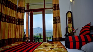 A room with a bed, curtains, a mirror, and a view of mountains. - Cool Mount Resort (Ballaketuwa)