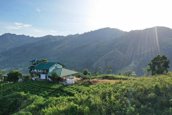 A green-roofed building with a sign reading "Coast Count" amidst lush green hills. - Cool Mount Resort (Ballaketuwa)