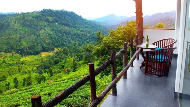 A balcony with a view of lush green hills and a wooden fence. - Cool Mount Resort (Ballaketuwa)