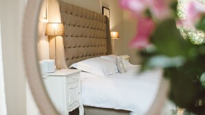 A bedroom with a tufted headboard, two bedside lamps, a white bed, and a nightstand with a lamp. - 15 Glasgow (Glasgow)