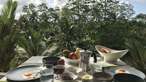 A breakfast table set outdoors with a view of lush greenery and trees. - Good Vibes Villas Retreat And Restaurant (Unawatuna)