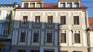 Un edificio de varios pisos con estilo arquitectónico clásico, con ventanas simétricas y molduras decorativas.