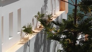 Ein Balkon mit Blick auf das Meer und entfernte Berge.