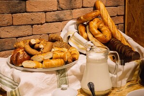 A variety of breads and pastries on a table with a milk jug. - Viva Boutique Hotel (Baku)