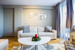 A modern living room with a sofa, a coffee table, and framed pictures on the wall. - Sunny Hills Ski (Chepelare)