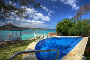 Une piscine avec vue sur l’océan et un belvédère.