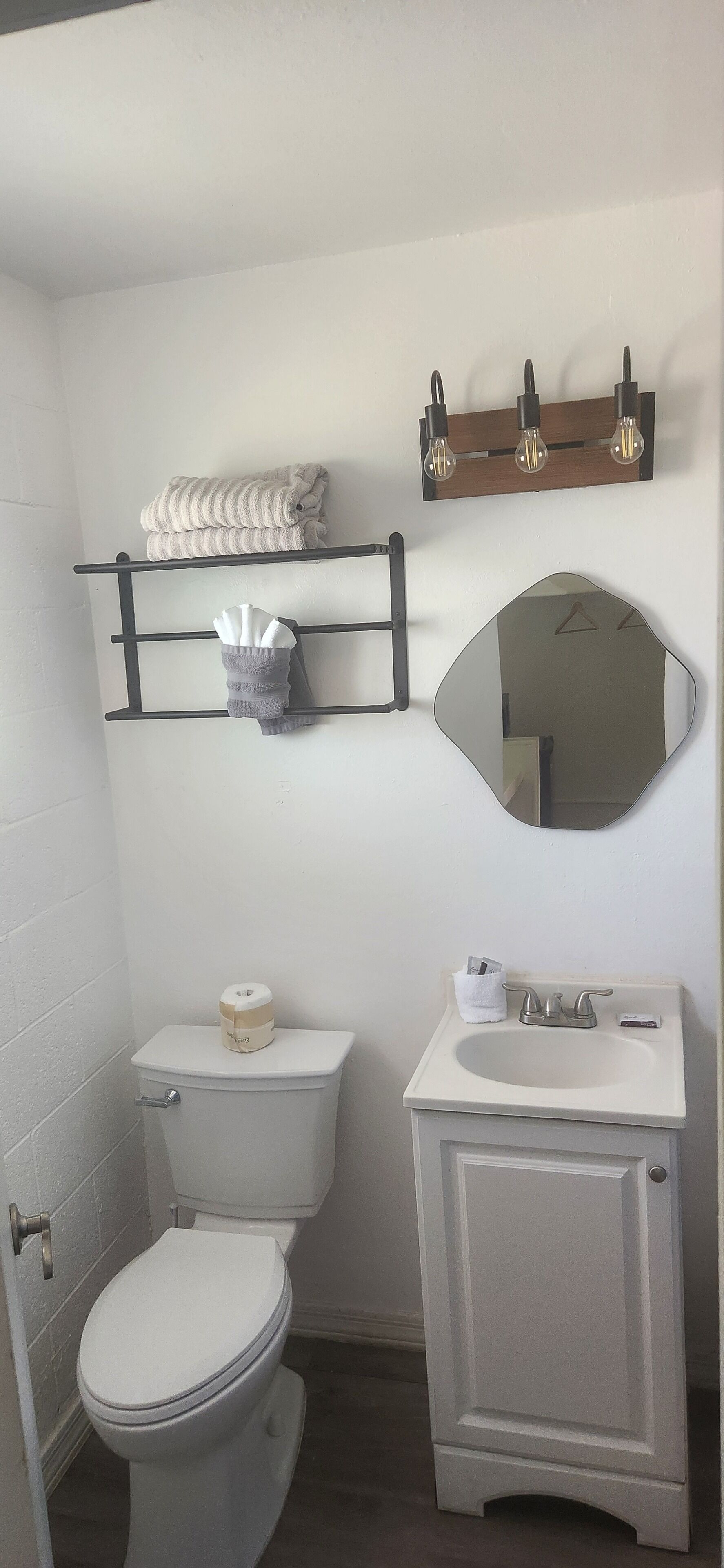 Baño con inodoro, lavamanos y toallero.